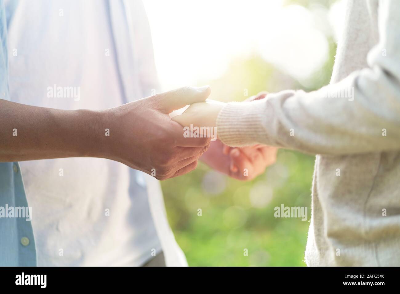 Jungen asiatischen Paar Liebhaber Hände halten im Freien Stockfoto