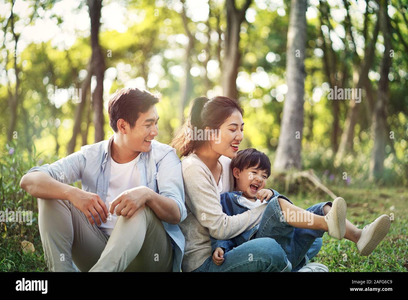 Junge asiatische Eltern und Sohn Spaß draußen im Park Stockfoto