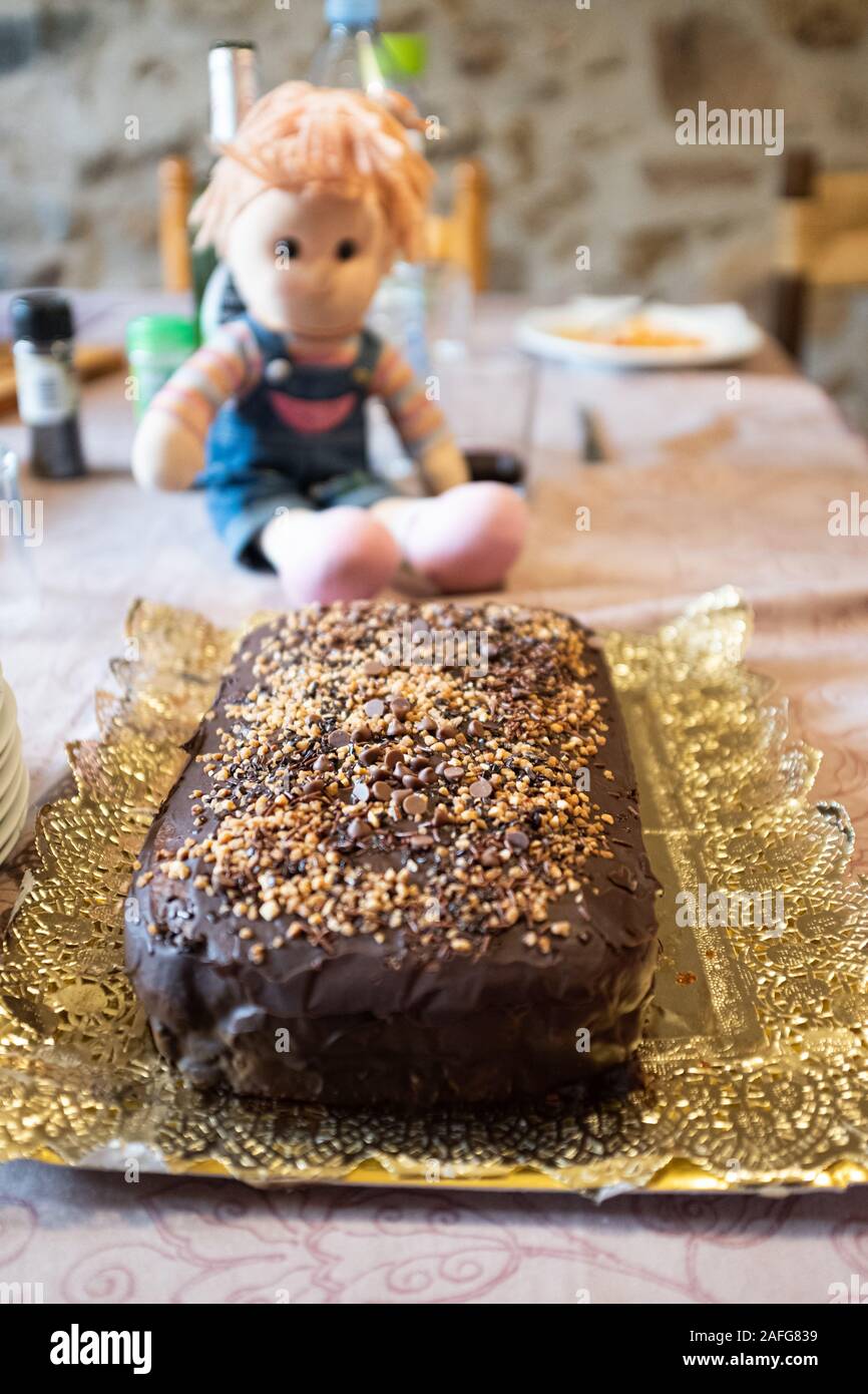 Leckere Schokoladenkuchen aus der Nähe immer noch mit einem Spielzeug Puppe auf Indoor ein Kid's Party Stockfoto