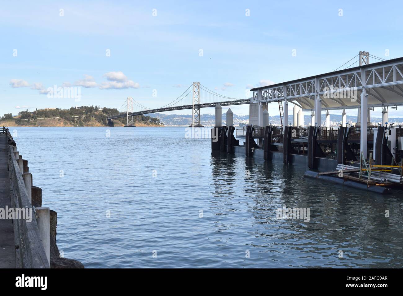 Die San Francisco Bay Bridge überquert Treasure Island, auf der linken Seite angezeigt. Vom Pier 14, Endstation der Alameda Linie der Bucht Fähre genommen. Stockfoto