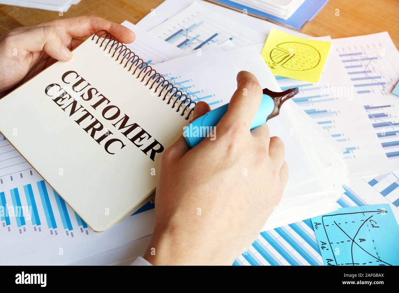 Mann hält Papiere mit Customer centric business Konzeption. Stockfoto