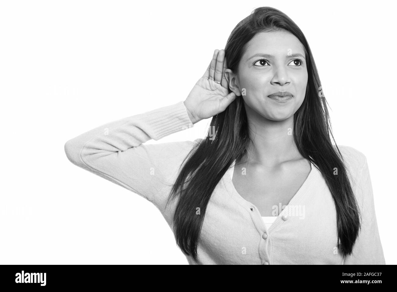 Nachdenkliche junge schöne brasilianische Frau hören in Schwarz und Weiß Stockfoto