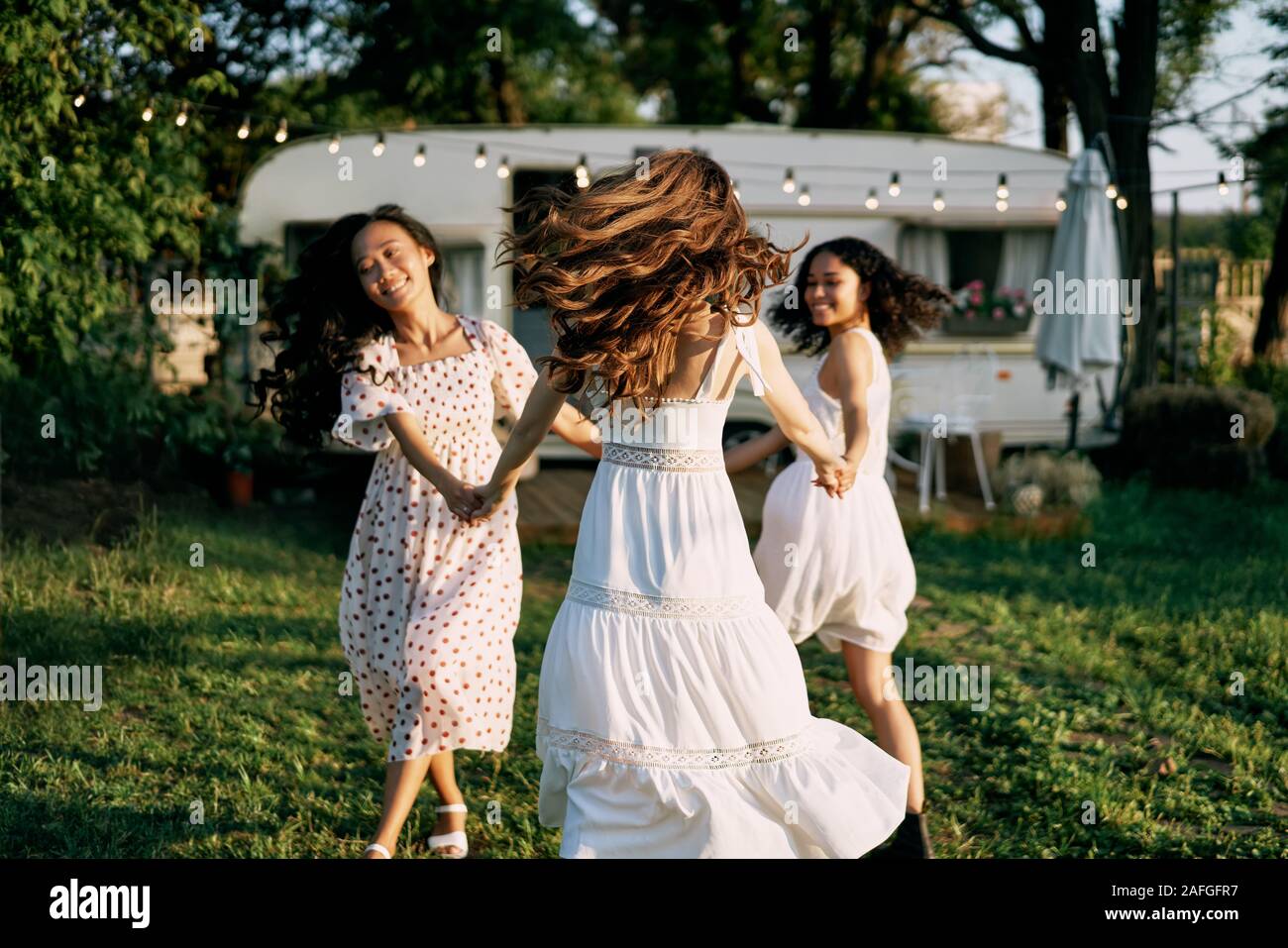 Gerne schöne Frauen tanzen im Freien auf Picknick. Multi-ethnische Mädchen haben gemeinsam Spaß im Sommer Reisen Urlaub genießen. Stockfoto