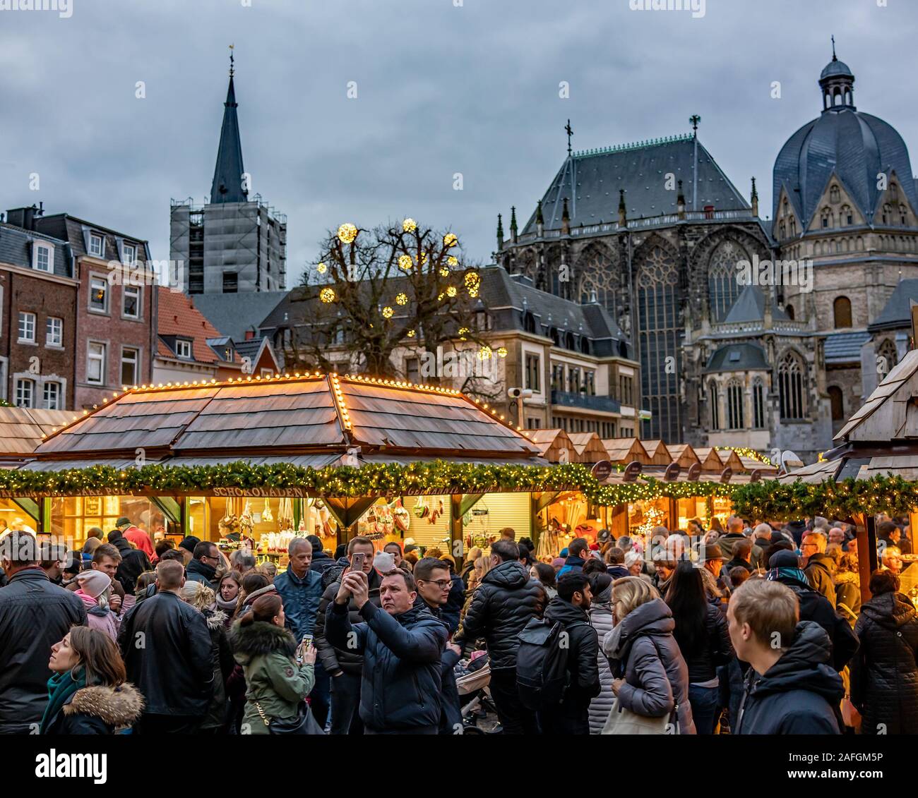 13 Nachtschwärmer genießen die 2019 Weihnachtsmarkt in Aachen, Deutschland wie das Licht verschwindet in der Dunkelheit Stockfoto