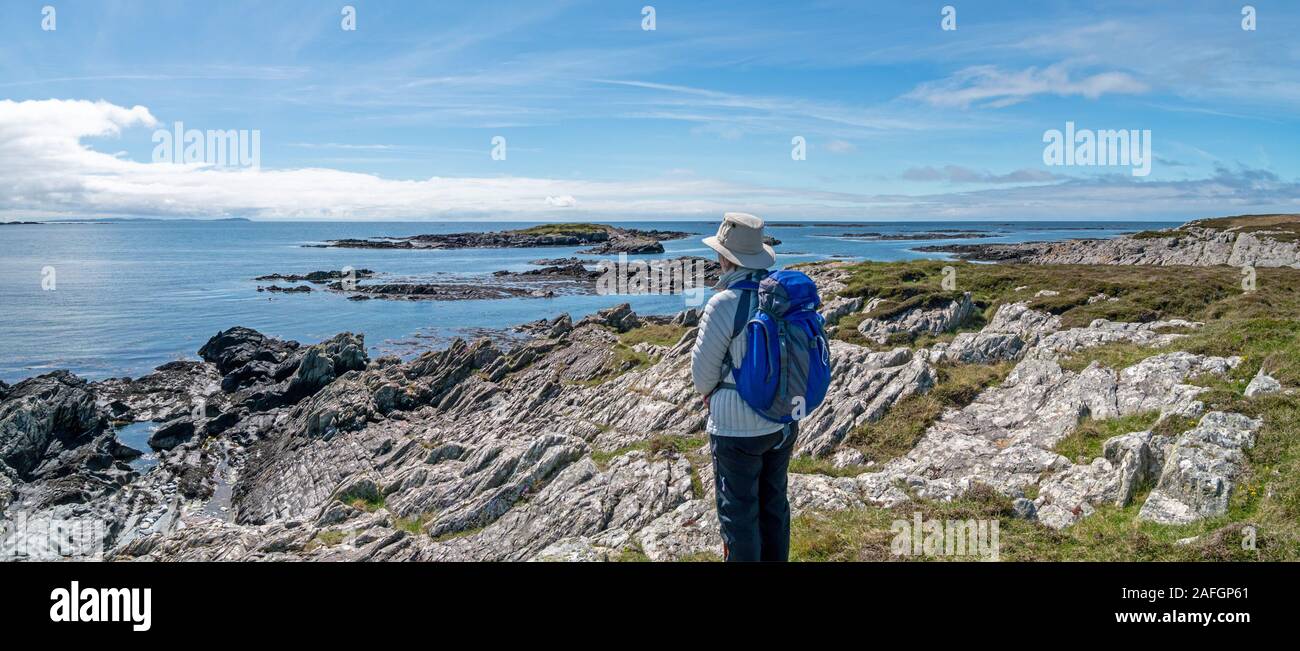 Urlauberin bewundert Panoramablick auf Atlantik und die Küste in der Nähe von Ardskenish, Insel Colonsay, Scotland, UK Stockfoto