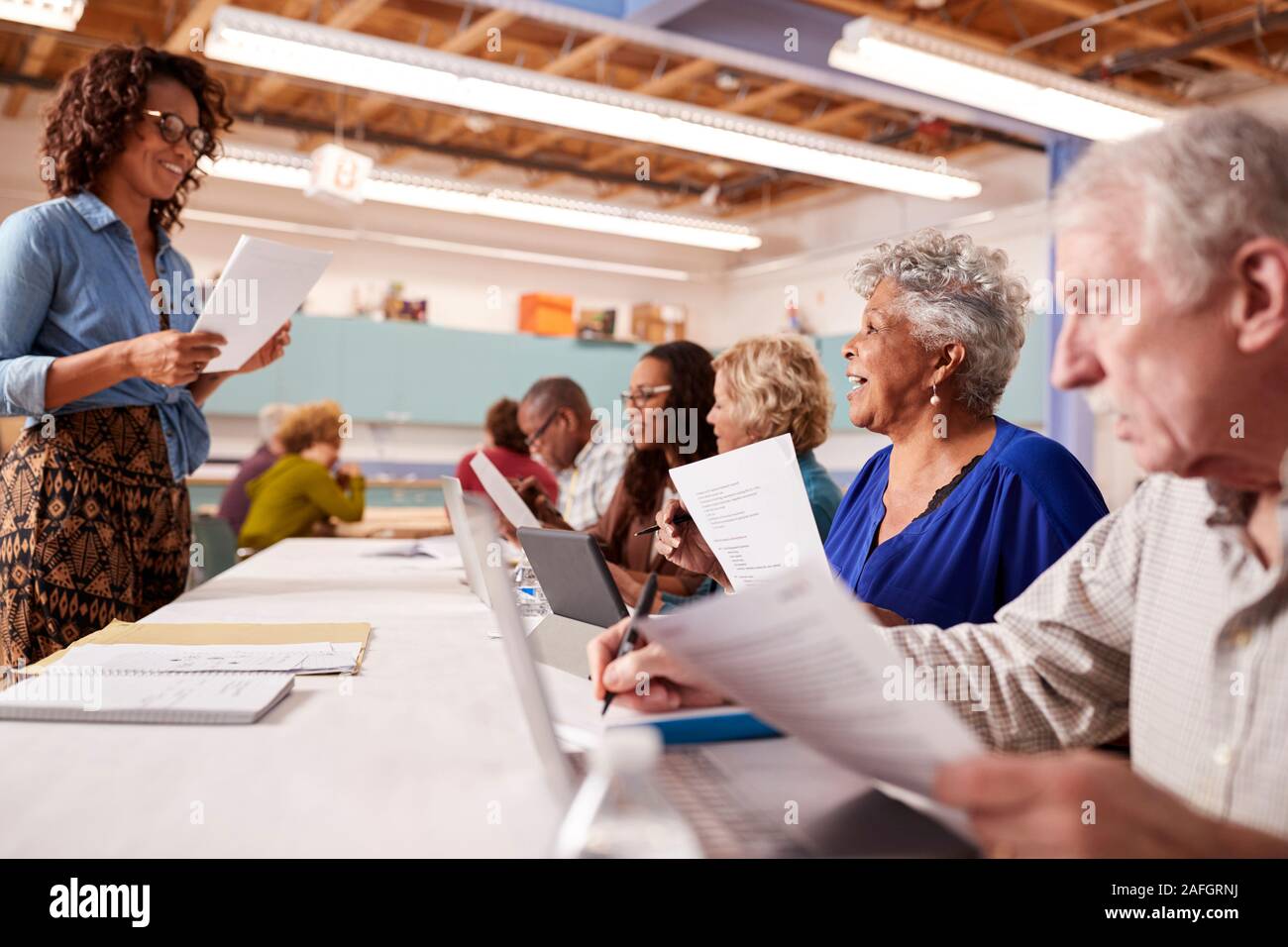 Gruppe von pensionierten Senioren die Teilnahme an es Klasse im Community Center mit dem Lehrer Stockfoto