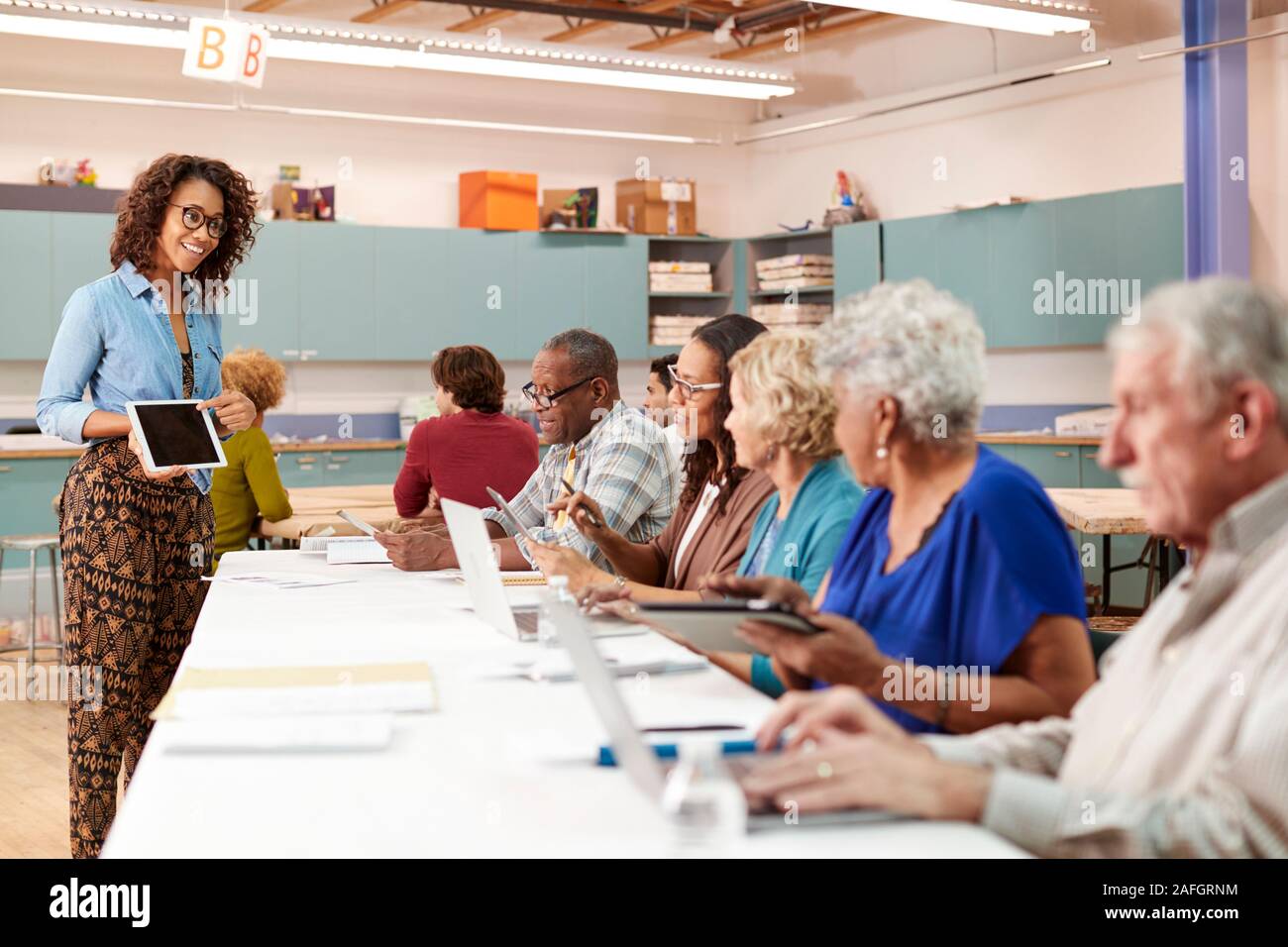 Gruppe von pensionierten Senioren die Teilnahme an es Klasse im Community Center mit dem Lehrer Stockfoto