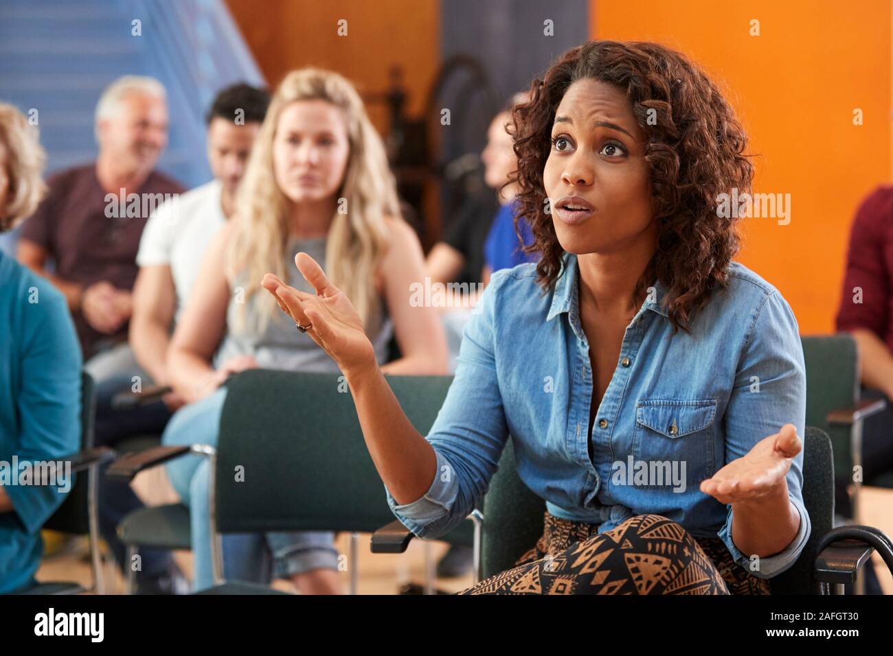 Frustrierte Frau Fragen Stellen in der Nachbarschaft Treffen im Gemeindezentrum Stockfoto