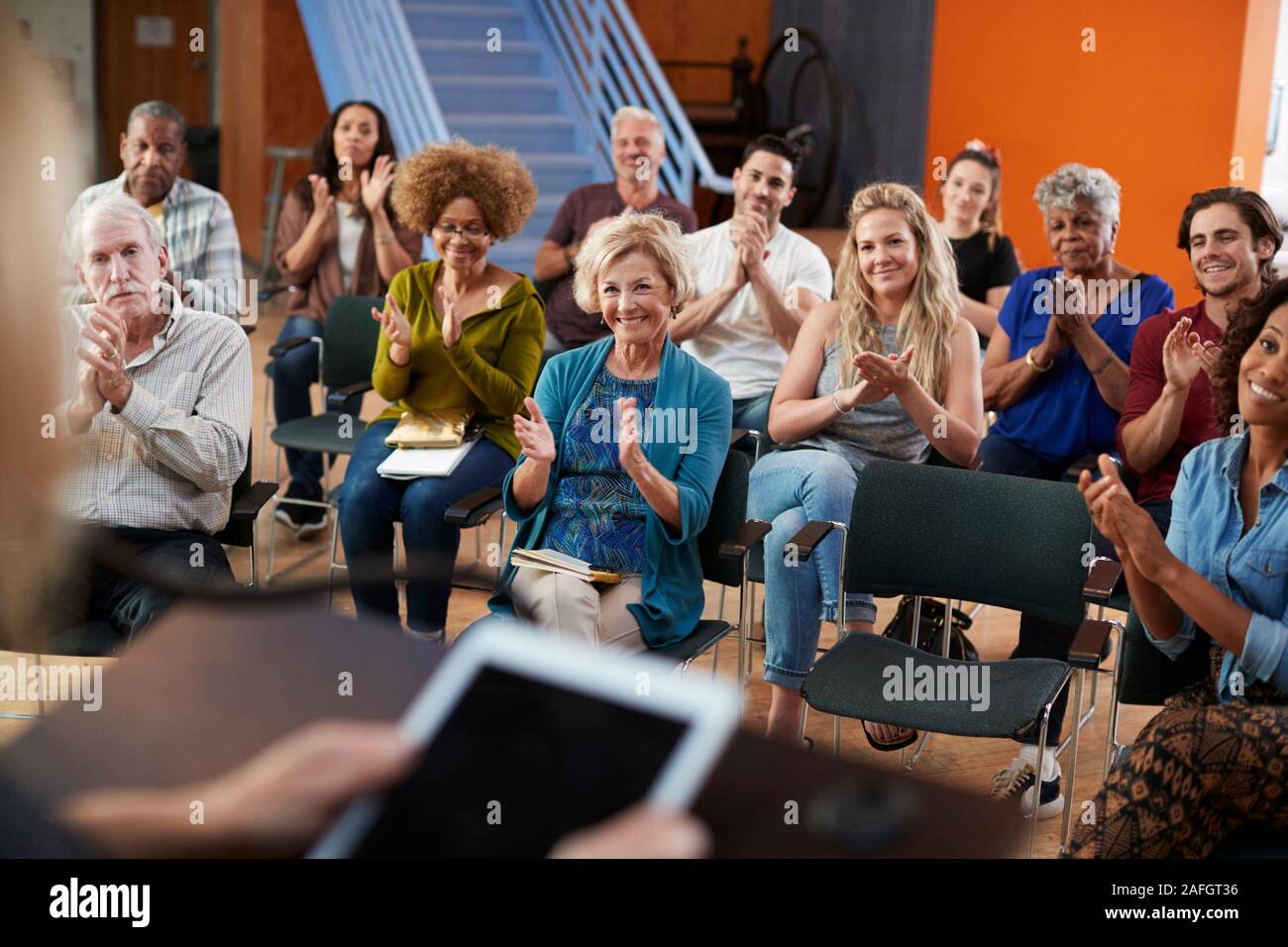 Gruppe die Teilnahme an Nachbarschaft Treffen applaudieren Lautsprecher im Community Center Stockfoto