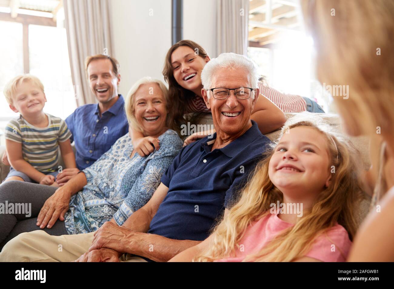 Multi-Generation Familie sitzt auf dem Sofa zu Hause Entspannen und Plaudern Stockfoto