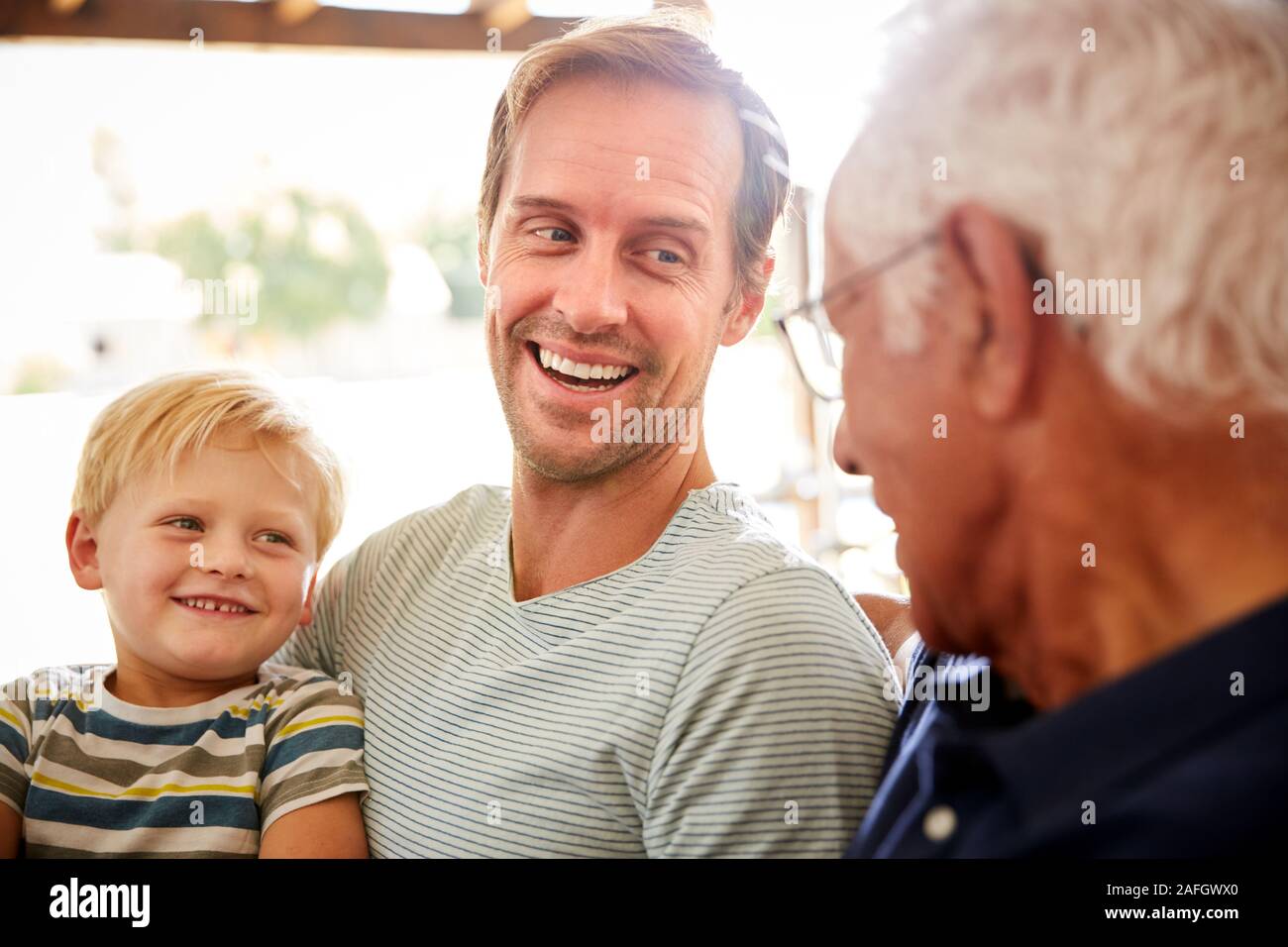 Vater mit erwachsener Sohn und Enkel Entspannen auf dem Sofa und Sprechen zu Hause Stockfoto
