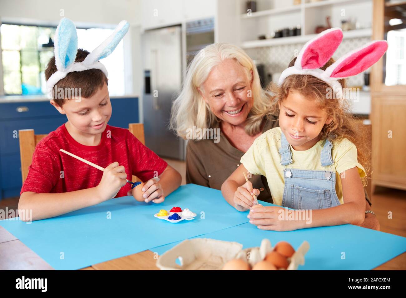 Großmutter mit Enkel tragen Rabbit Ears Dekoration Ostern Eier zu Hause zusammen Stockfoto