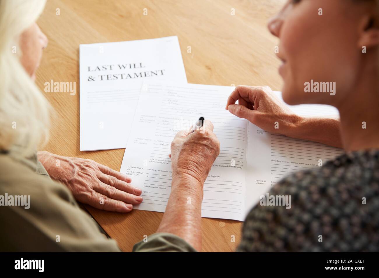 Freundin helfen ältere Frau zu kompletten Testament zu Hause Stockfoto