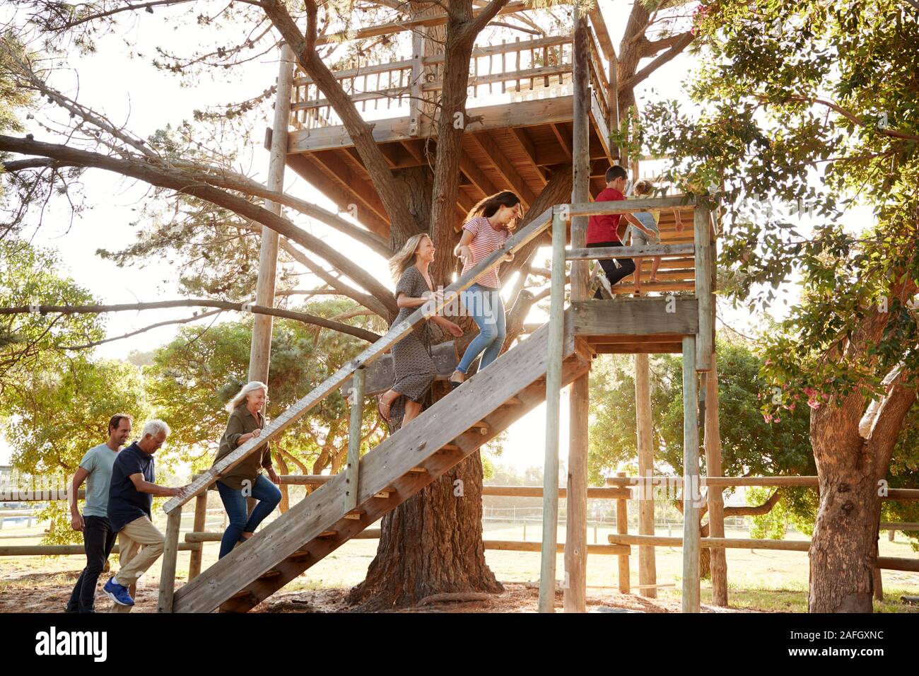 Multi-Generation Familie Klettern Outdoor Holz- Plattform zu Tree House im Garten Stockfoto