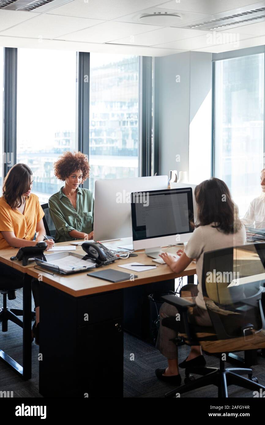 Vier weibliche kreative Kollegen zusammen die Arbeit in einem Büro, Vertikal, Erntegut Stockfoto