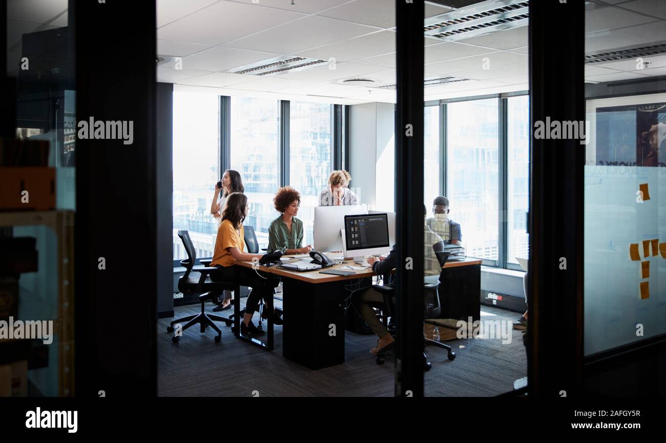 Creative Business Team gemeinsam in einer ungezwungenen, Büro, durch Glaswand gesehen Stockfoto
