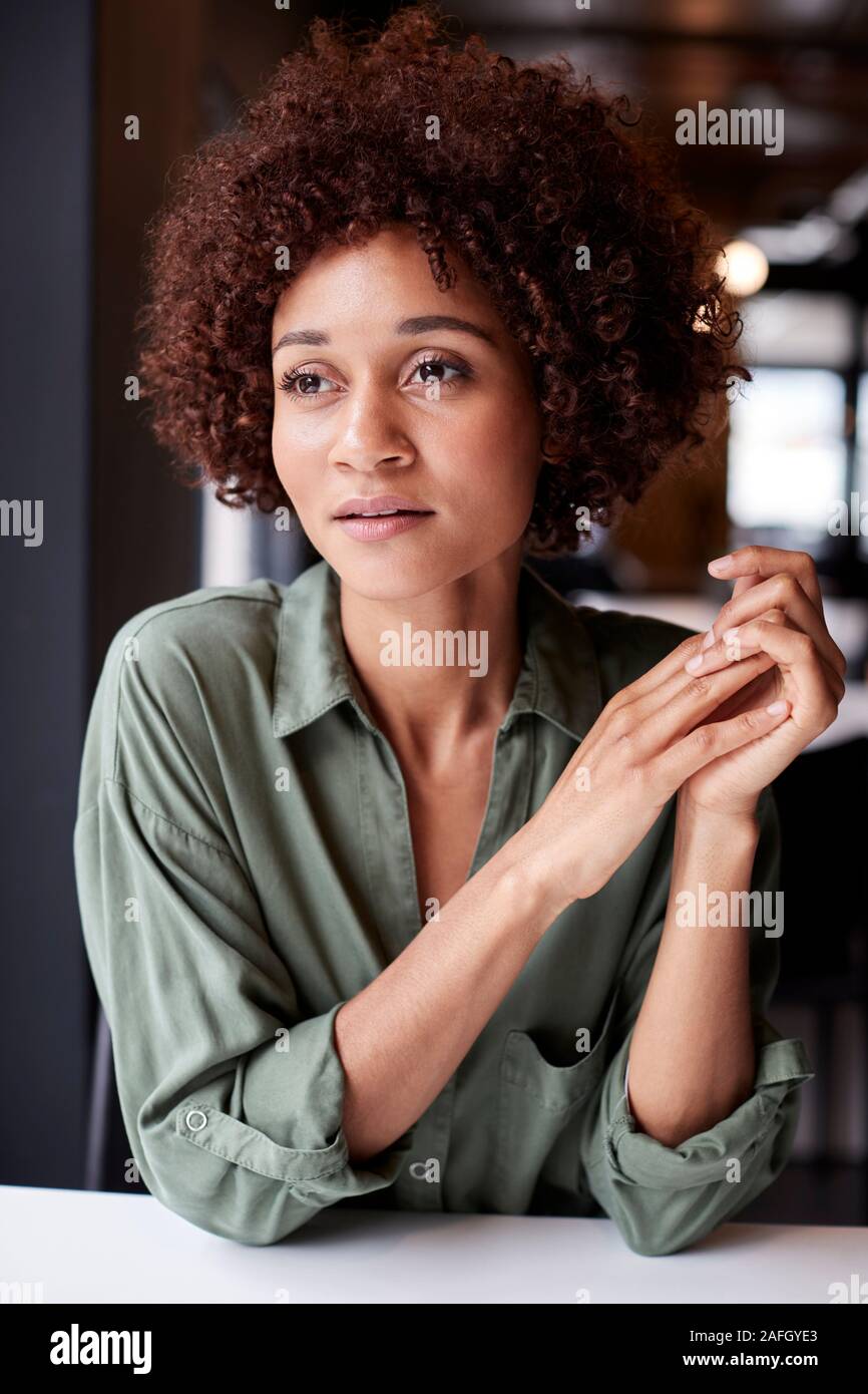 Tausendjährige schwarze weibliche Kreativität in einem Büro entfernt, die in der Kontemplation, in der Nähe Stockfoto