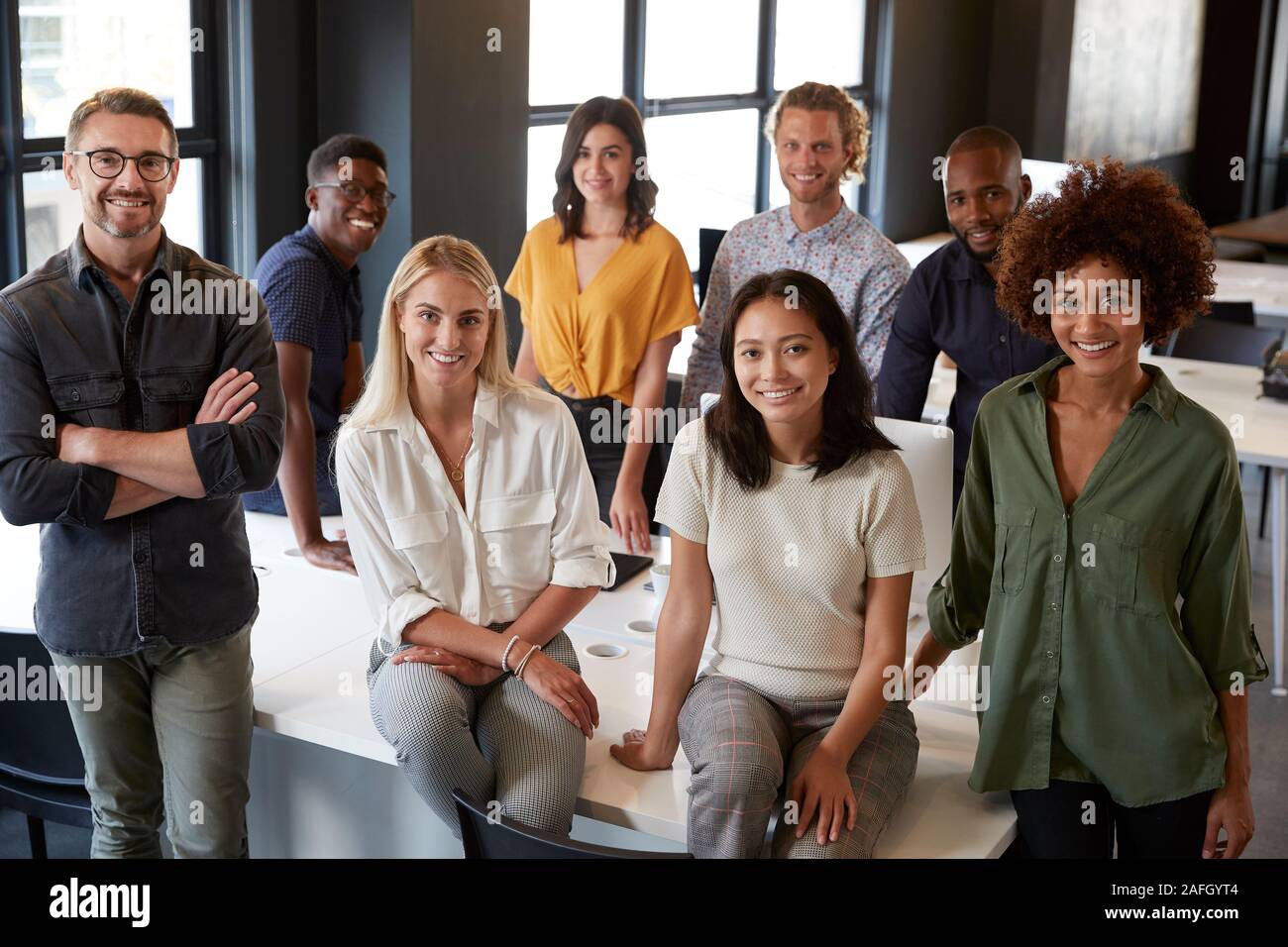 Porträt einer Creative Business Team stützte sich auf einen Schreibtisch, lächelnd in die Kamera im Büro, Erhöhte Ansicht Stockfoto
