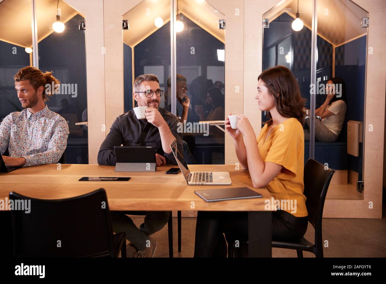 Kreative Kollegen an einem Tisch sitzen, Kaffee trinken und reden in Ihrem Büro Kantine, in der Nähe Stockfoto