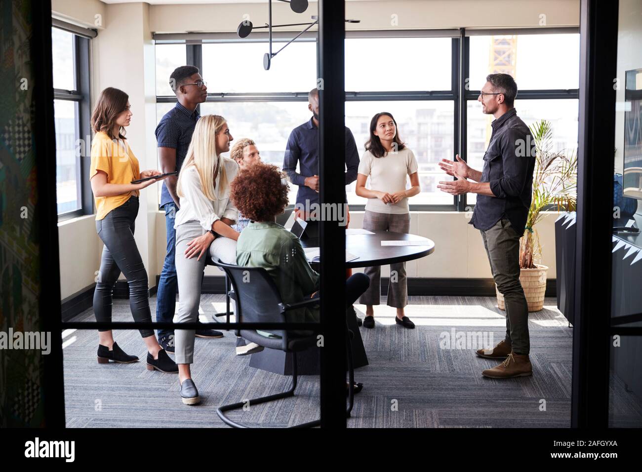 Creative Business Team in einem Konferenzraum Hören zu einem informellen Präsentation, vom Eingang gesehen Stockfoto