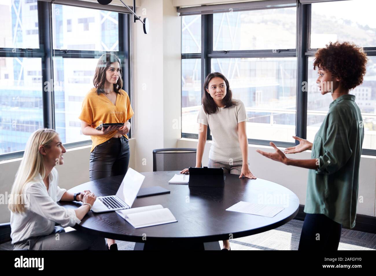 Weibliche Creatives in einem Konferenzraum hören auf Ihre Kollegen zu einer informellen Präsentation Stockfoto