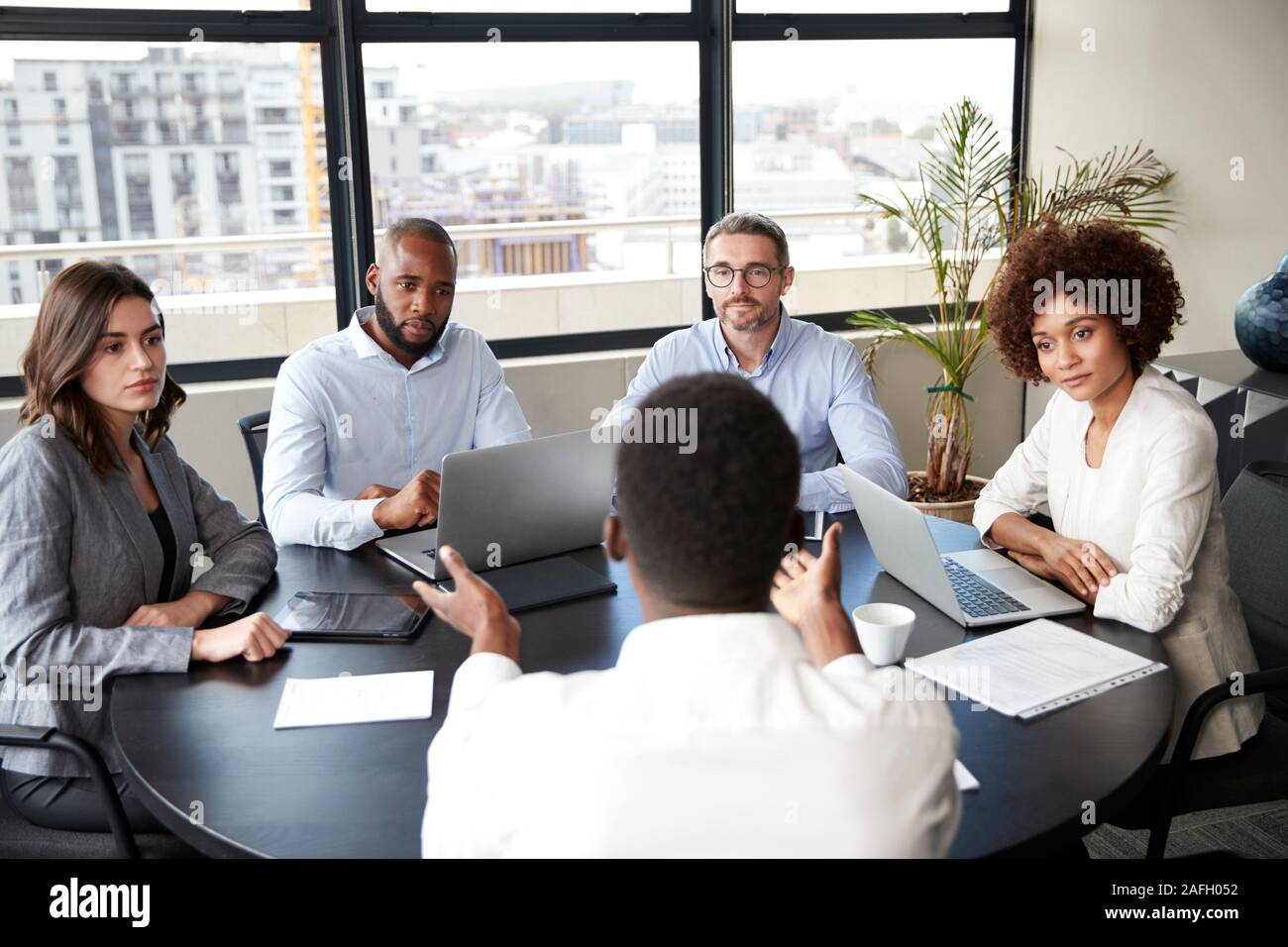 Corporate Business Personen in einem Meeting Zimmer hören zu einem Kollegen sprechen, Erhöhte Ansicht Stockfoto