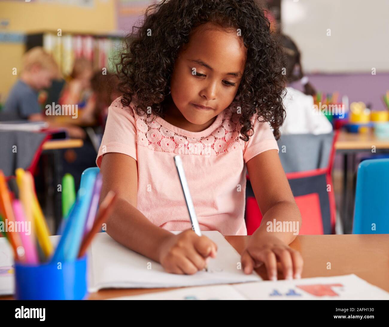 Konzentration der weiblichen Grundschüler Arbeiten am Schreibtisch Stockfoto