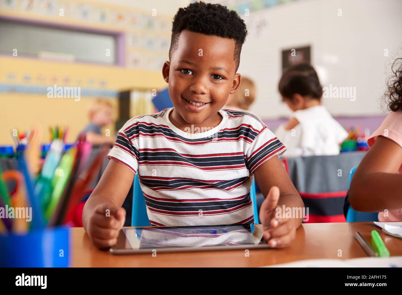 Portrait der männlichen Schüler in der Volksschule Zeichnung mit digitalen Tablette im Klassenzimmer Stockfoto