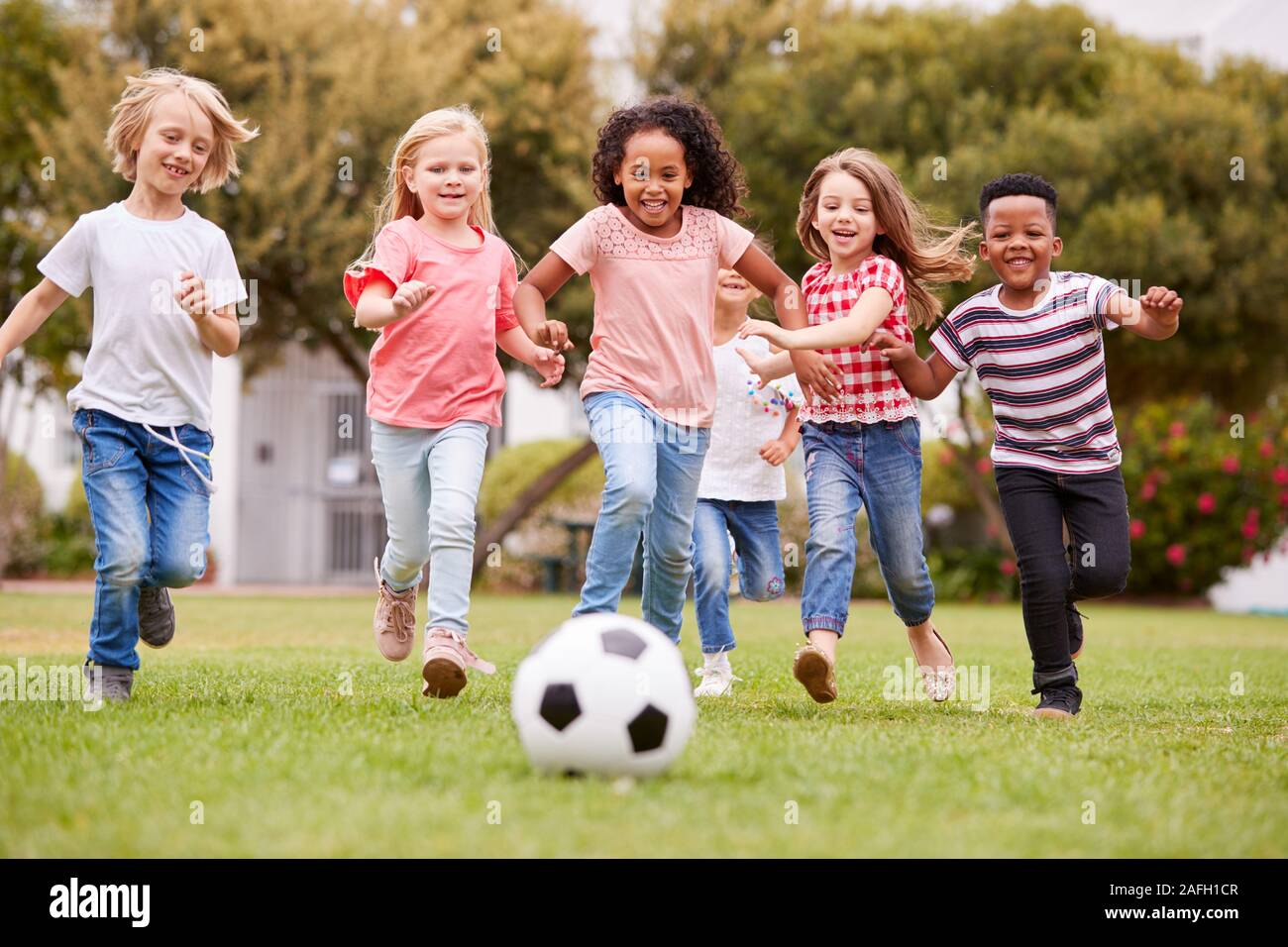 Gruppe von Kindern Fußball spielen mit Freunden im Park Stockfoto