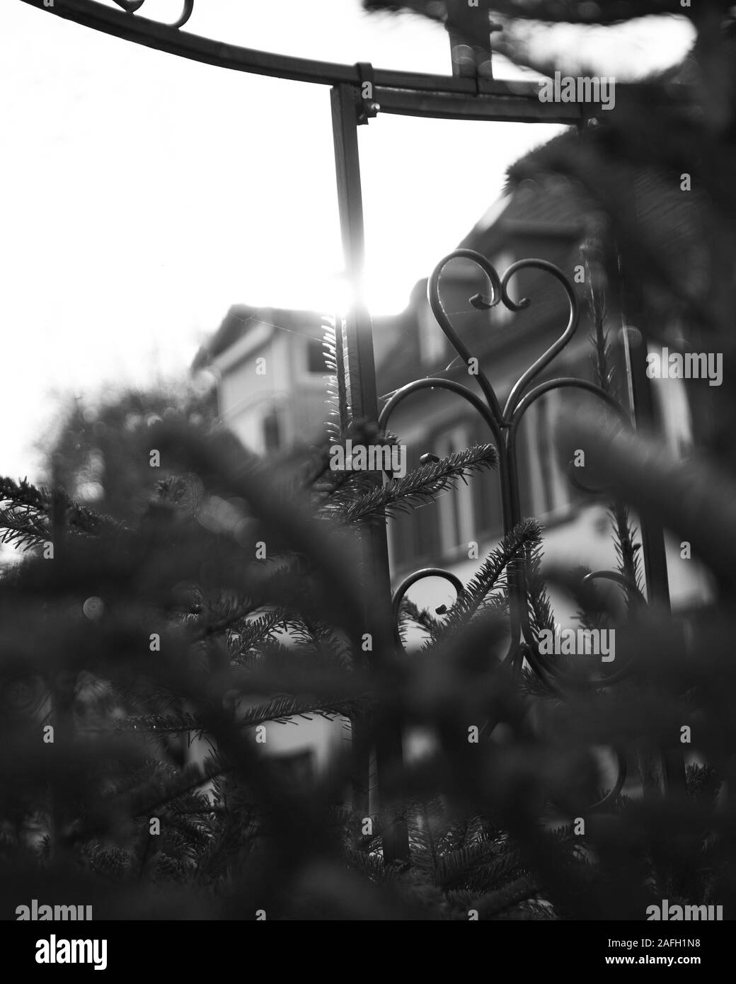 Vertikale Graustufenaufnahme eines Metalltors vor Ein Gebäude Stockfoto