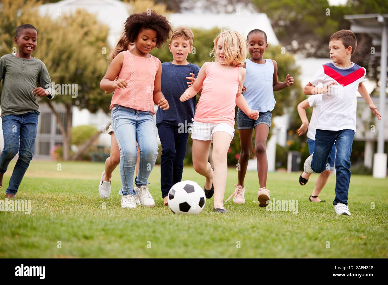 Gruppe von Kindern Fußball spielen mit Freunden im Park Stockfoto