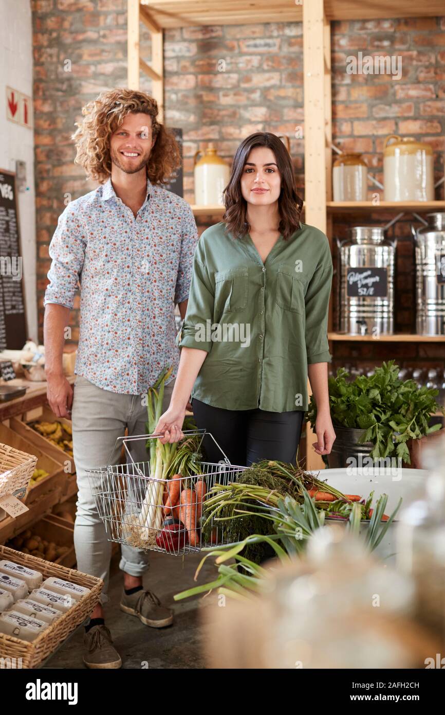 Portrait von Paar Kaufen Frisches Obst und Gemüse in nachhaltige Kunststoff sich Lebensmittelgeschäft Stockfoto