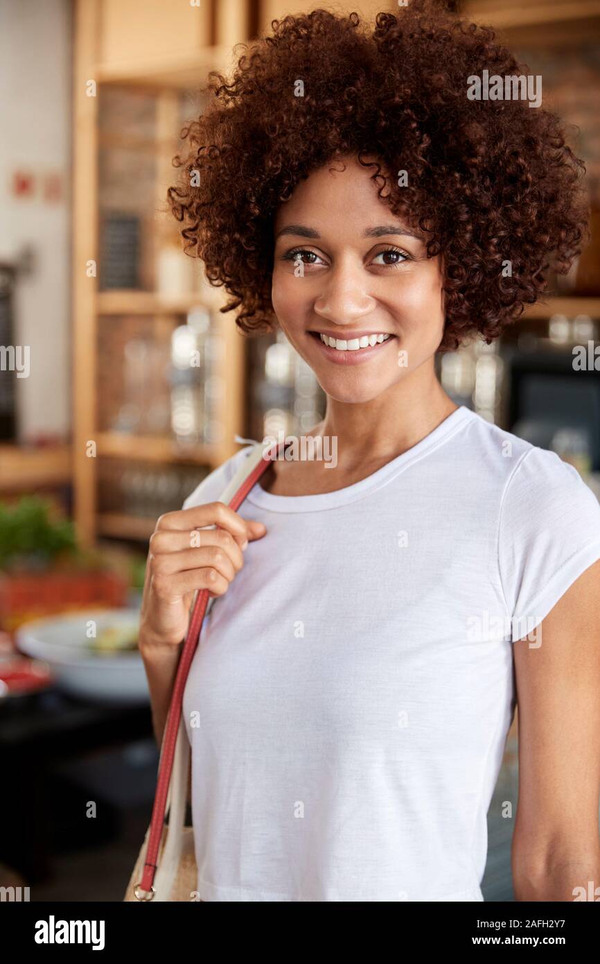 Portrait von Frau Einkaufen In nachhaltige Kunststoff sich Lebensmittelgeschäft Stockfoto