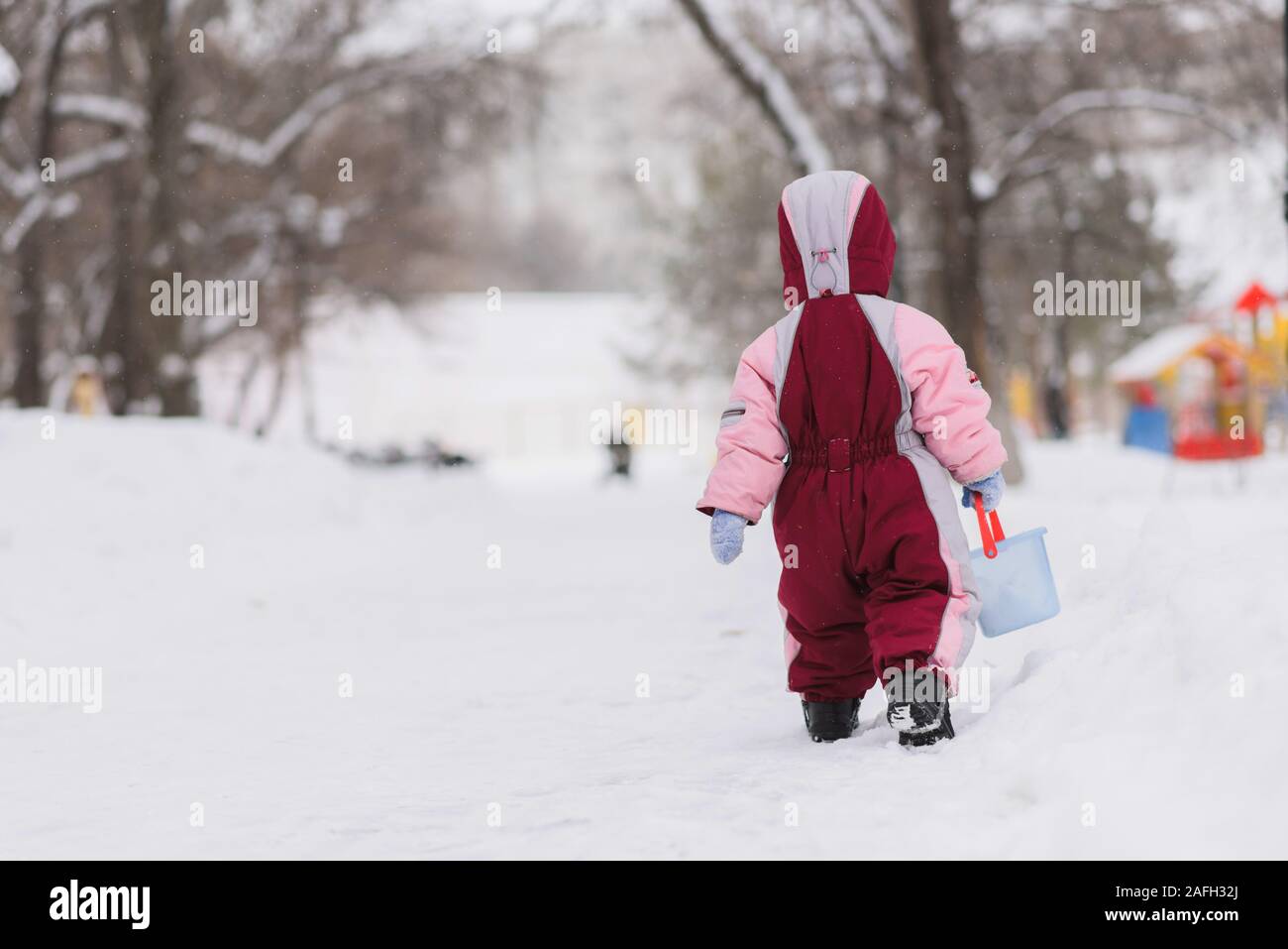 Kleines Kind spielt auf dem Spielplatz im Winter Stockfoto