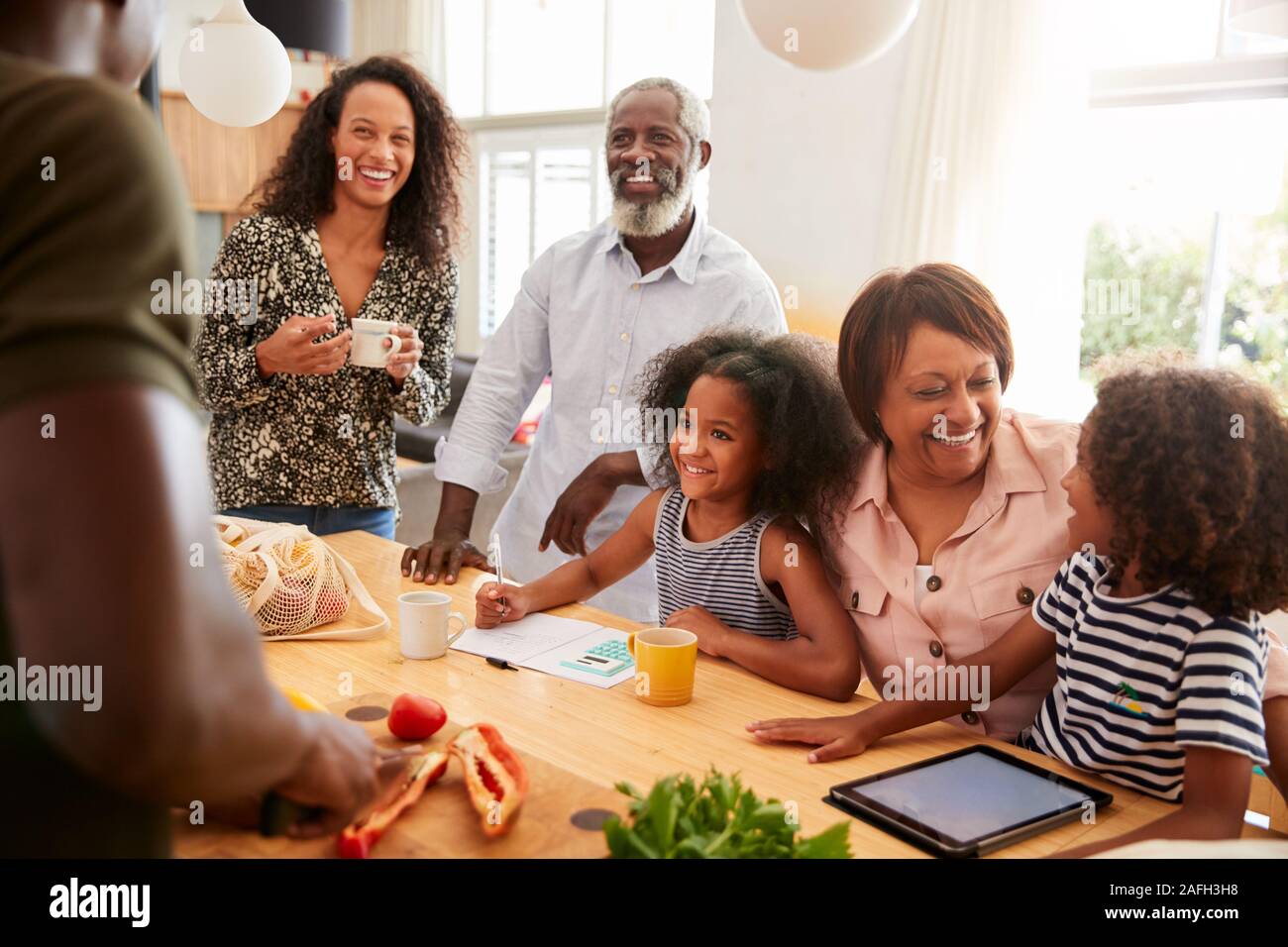 Großeltern mit Enkelkindern Spielen als Familie bereitet Essen sitzen Stockfoto