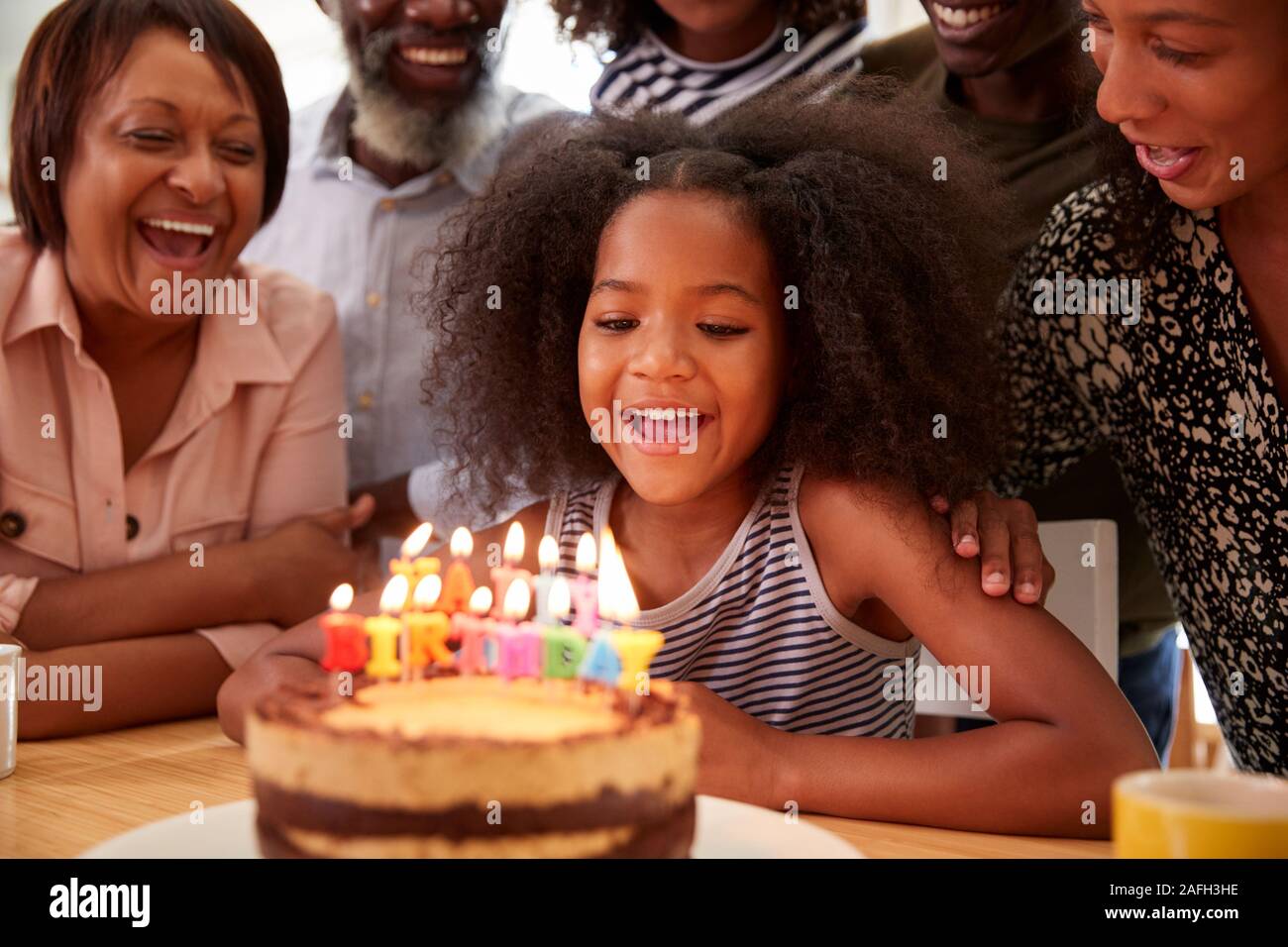 Multi-Generation Familie feiern Enkelinnen Geburtstag zu Hause mit Kuchen und Kerzen Stockfoto