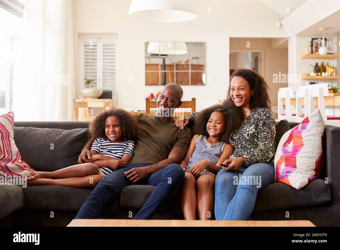 Familie sitzt auf dem Sofa zu Hause und sehen auf einem Fernsehgerät zusammen Stockfoto
