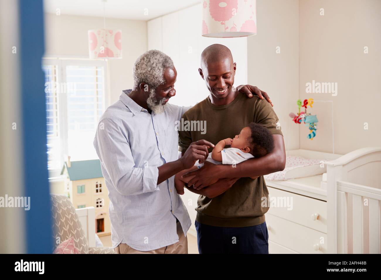 Stolze Großvater mit erwachsenen Sohn Kuscheln Baby Enkel in Kindergärten zu Hause Stockfoto
