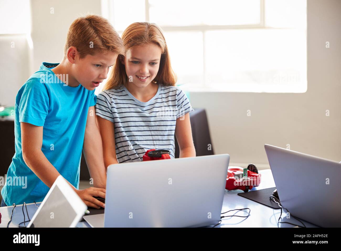 Zwei Schüler der Klasse nach der Schule Computer Coding Programmieren lernen Roboter Fahrzeug Stockfoto