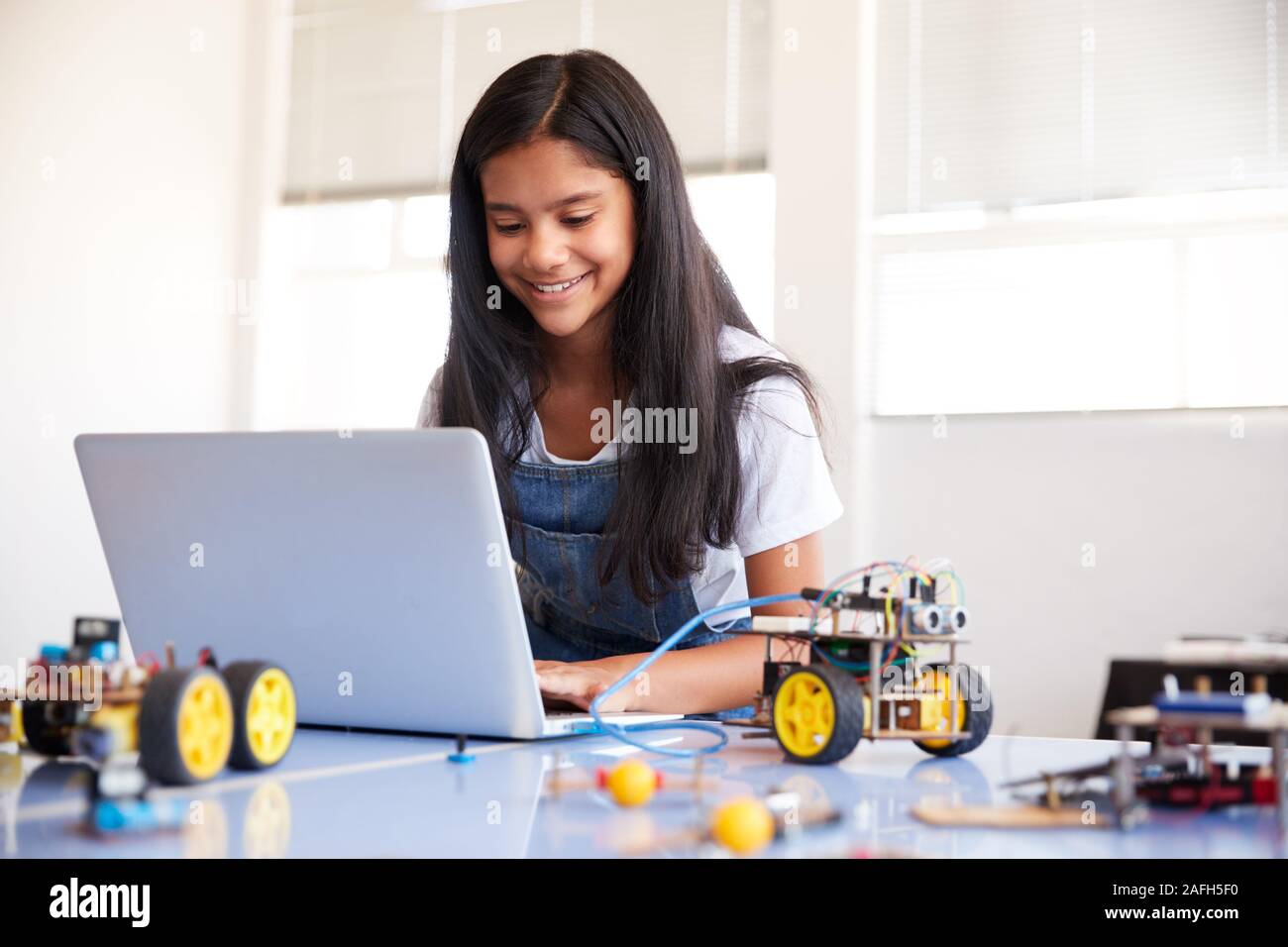 Weibliche Schüler Bauen und Programmieren Roboter Fahrzeug nach der Schule Computer Coding Klasse Stockfoto