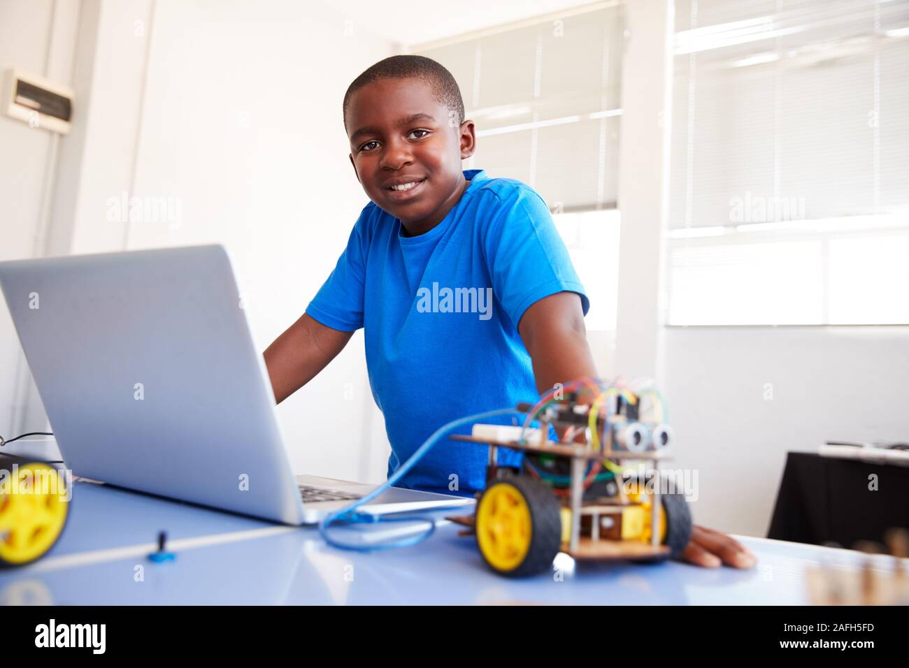 Portrait der männlichen Schüler Bauen und Programmieren Roboter Fahrzeug in der Schule Computer Coding Klasse Stockfoto