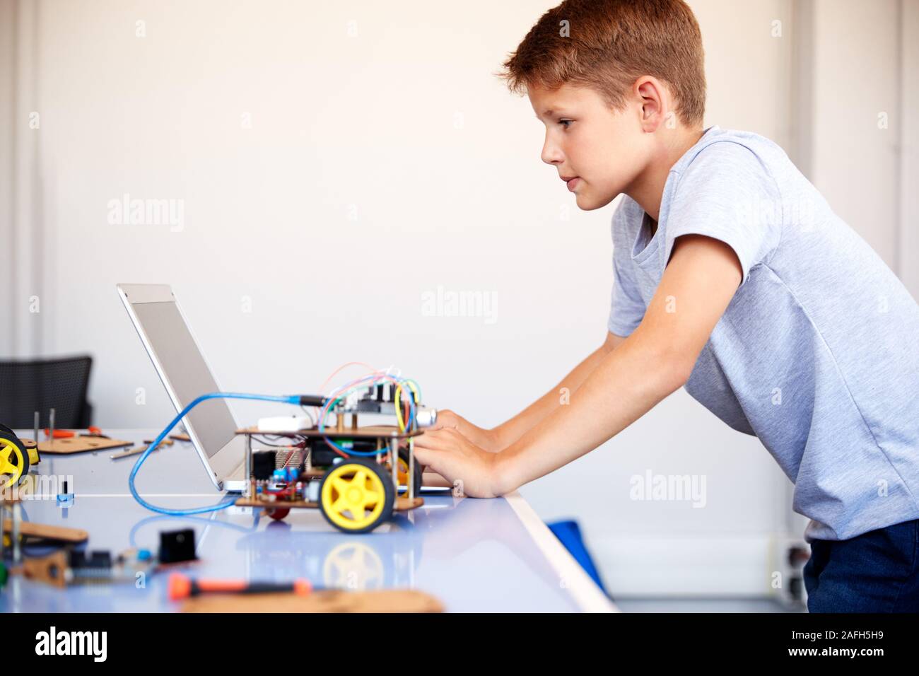 Männliche Schüler Bauen und Programmieren Roboter Fahrzeug in der Schule Computer Coding Klasse Stockfoto