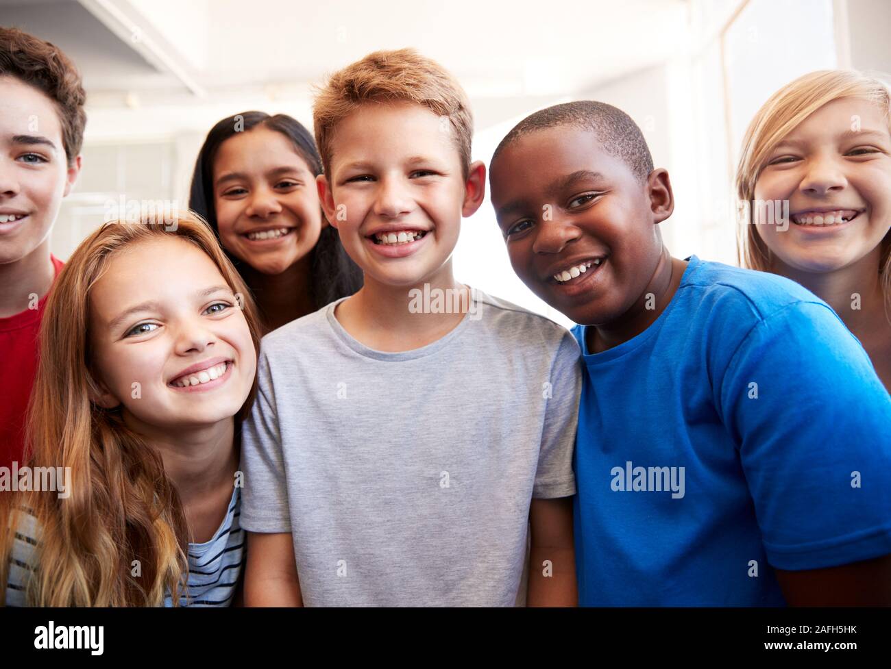 Portrait von lächelnden Männlichen und weiblichen Schüler in der Grundschule Klassenzimmer Stockfoto