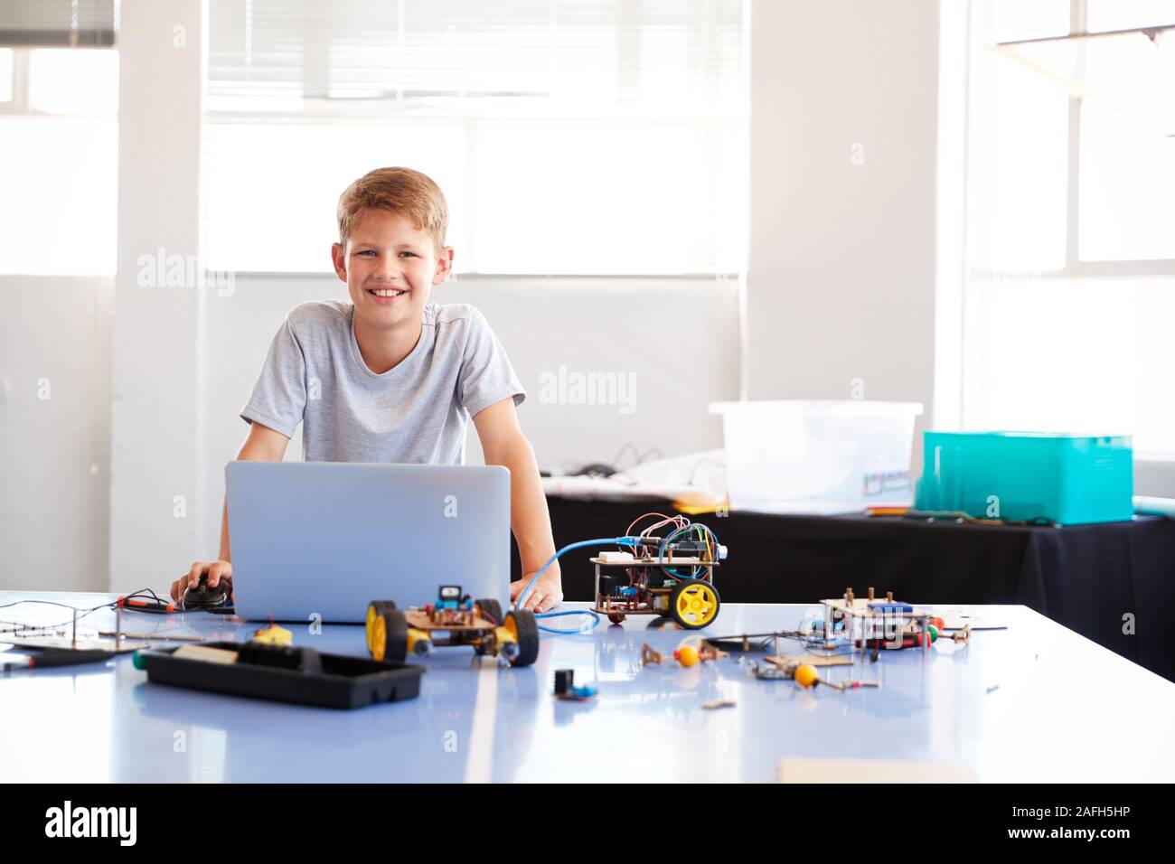 Portrait der männlichen Schüler Bauen und Programmieren Roboter Fahrzeug in der Schule Computer Coding Klasse Stockfoto
