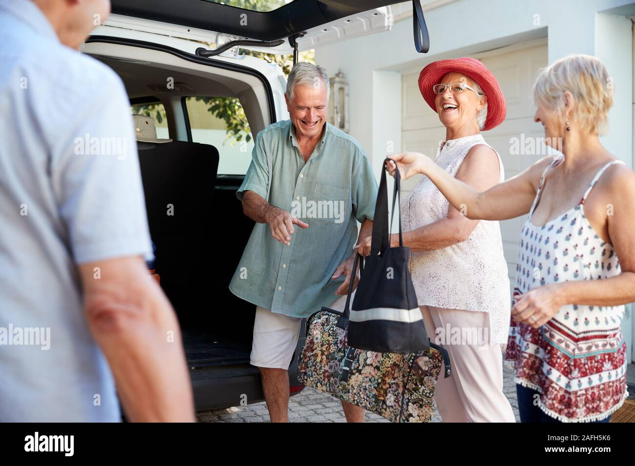 Gruppe von älteren Freunden laden das Gepäck in den Kofferraum des Autos Zu für Urlaub Stockfoto Gruppe von älteren Freunden laden das Gepäck in den Kofferraum des Autos Zu für Urlaub Stockfoto