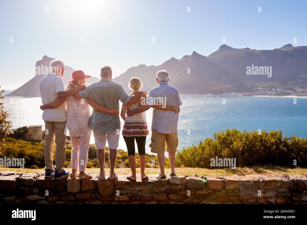 Ansicht der Rückseite des Älteren Freunde besuchen touristische Sehenswürdigkeit auf Gruppe Ferienhäuser stehen auf Wand Stockfoto