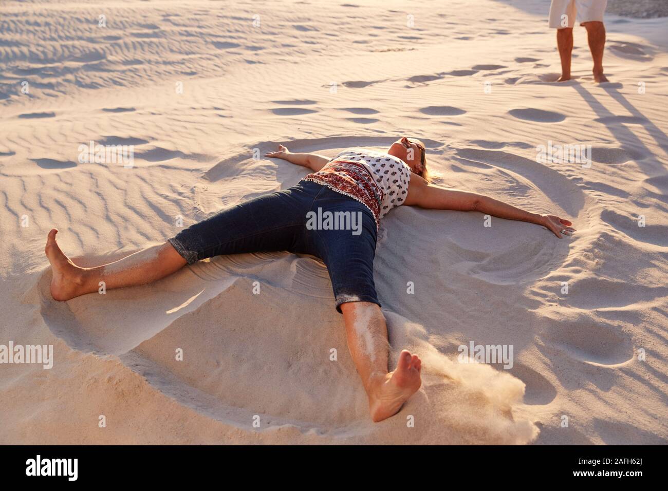 Senior liegende Frau am Strand, Sand Engel auf Urlaub Stockfoto Senior liegende Frau am Strand, Sand Engel auf Urlaub Stockfoto
