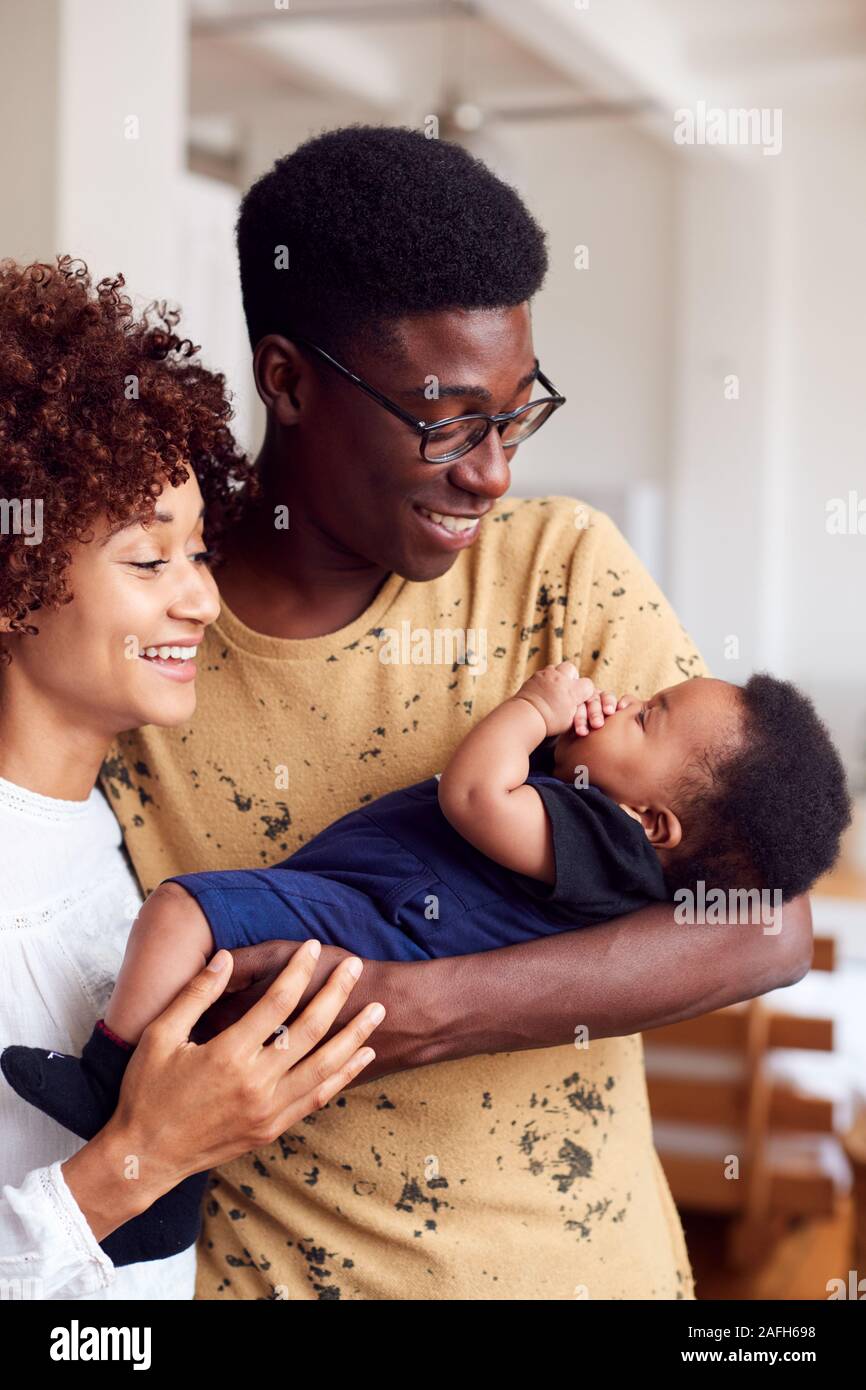 Liebevolle Eltern mit neugeborenen Babys zu Hause in Loft Apartment Stockfoto