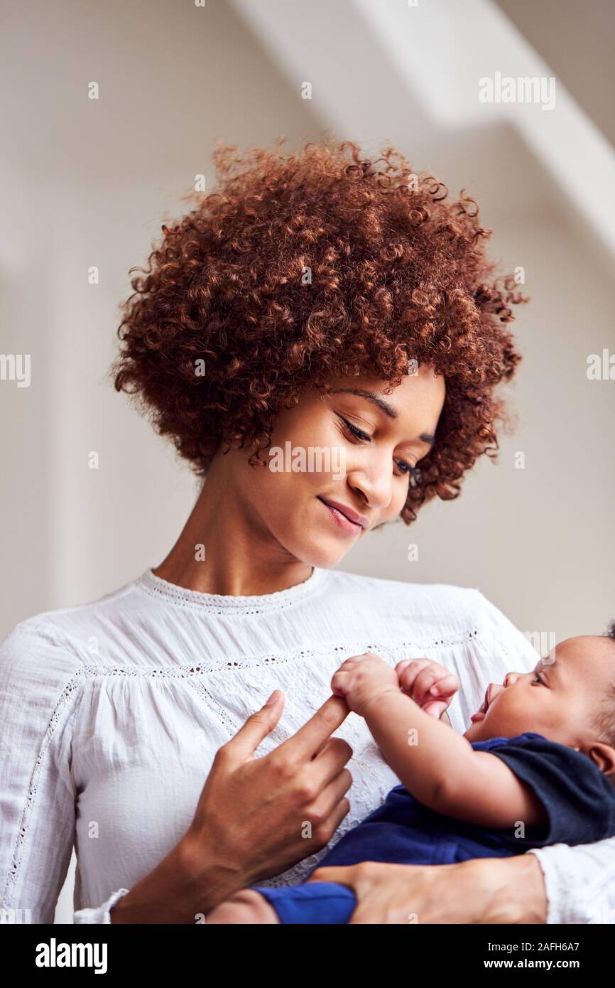 Liebevolle Mutter, neugeborenes Baby zu Hause in Loft Apartment Stockfoto