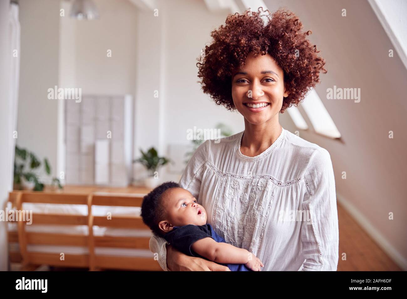 Porträt der liebenden Mutter, neugeborenes Baby zu Hause in Loft Apartment Stockfoto